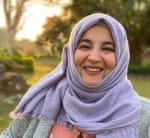 Profile picture of Tanzila, a woman with brown skin and purple hijab, smiling broadly.